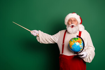 Fototapeta premium Santa Claus with globe and wand on green background presenting a playful festive travel theme and holiday magic