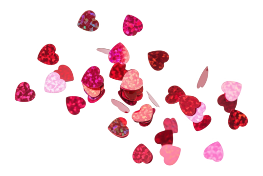 Scattered red and pink heart shaped confetti on white background. Romantic, festive, celebration, love concept. Valentines Day decorations.