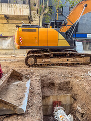 Excavator Working on Urban Construction Site with Deep Trench
