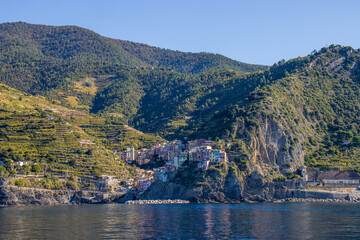 Panoramic view of the Ligurian coast and the colorful villages of Cinque Terre as seen from the sea on a cruise ship on a clear day. Cinque Terre, Liguria, Italy