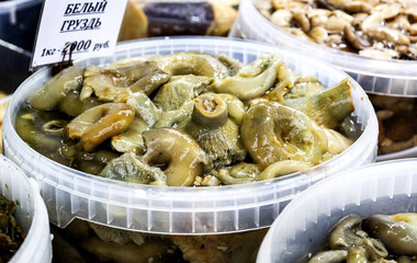 Pickled mushrooms sold on the market. Marinated mushrooms, appetizer of pickled mushrooms