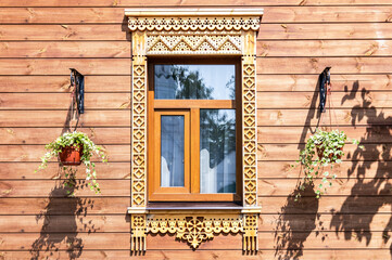 Facade of village house decorated with wooden carvings, platbands, wooden lace ornament