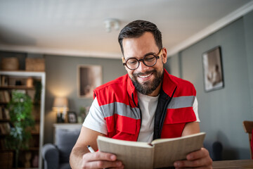 Paramedic man reading journal smiling taking a break