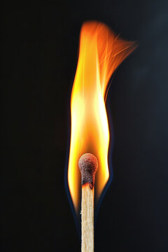 Burning match igniting a bright orange flame