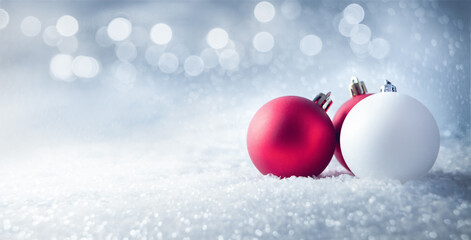 Red and white christmas balls on white snow background with copy space