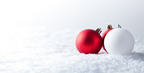 Red and white christmas balls on white snow background with copy space