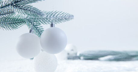 Christmas background with fir branches, white balls and bokeh.
