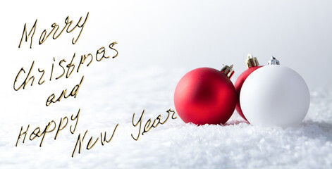 Merry Christmas and Happy New Year greeting card with red and white baubles on snow