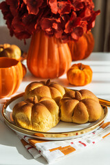 Autumn Table Setting with Pumpkin-Shaped Buns with Cinnamon, Mug, Flowers, and Seasonal Decor