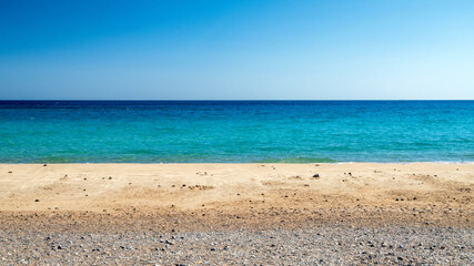 Obraz premium Mazida Ammos Beach, Crete, Greece, with turquoise sea, golden sand and clear blue sky in summer landscape showing Mediterranean coast and calm water