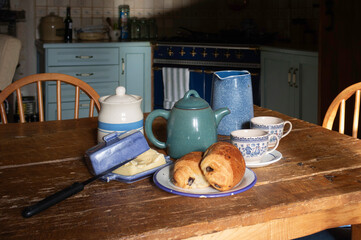 Breakfast with bread, butter and milk on a wooden table. Country house in France.
