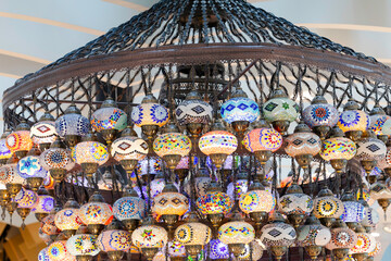 A large number of oriental lamps hang together suspended from the ceiling.
