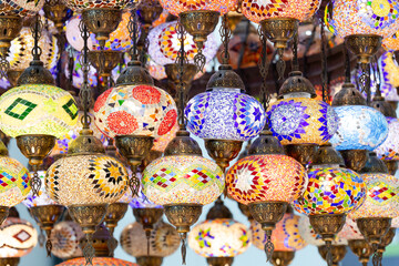 A large number of oriental lamps hang together suspended from the ceiling.