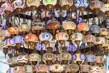 A large number of oriental lamps hang together suspended from the ceiling.