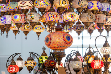 A large number of oriental lamps hang together suspended from the ceiling.