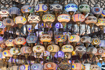 A large number of oriental lamps hang together suspended from the ceiling.