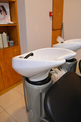 A modern hair salon interior with black chairs, large mirrors, and minimalist decor. Concept for a beauty salon professional's workspace, modern customer service