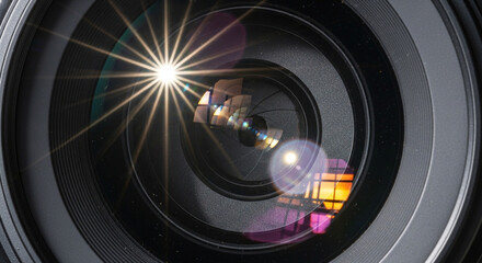 Stunning macro of a camera lens with a beautiful starburst flare effect, ideal for photography blogs, tech reviews, or visual storytelling about optics