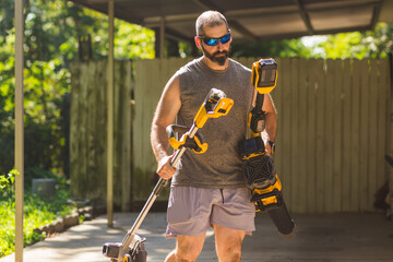 Man carries various yardwork equipment