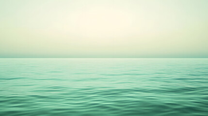 Obraz premium A tranquil view of the ocean with gentle waves under a softly lit, pale sky, showcasing a serene natural landscape.