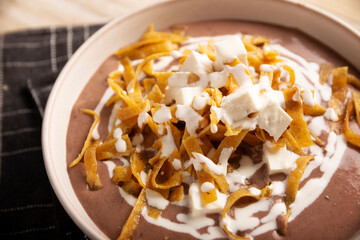 Creamy bean soup. In Mexico known as Crema de Frijoles, nutritious homemade food recipe, commonly accompanied with cheese, cream, avocado and corn tortilla cut into strips and fried.