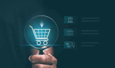 Online shopping and digital commerce concept. Hand holding magnifying glass focusing on glowing shopping cart icon. E-commerce, product search, delivery, payment and modern retail technology. © Waatsana