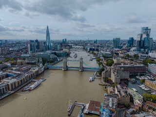 Stunning aerial view of Tower Bridge in London, spanning the River Thames with the city skyline in the background &mdash; blending historic architecture and modern urban beauty. London Bridge