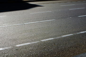 Sleek asphalt road with white lane markings offers a modern texture and urban pattern perfect for transportation or infrastructure designs and background usage