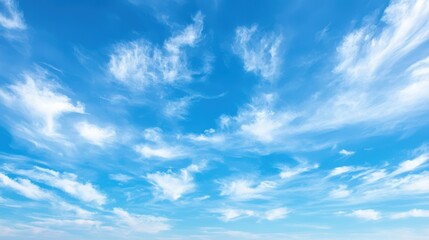 Fototapeta premium A serene blue sky adorned with soft, wispy clouds, creating a peaceful and expansive atmosphere.