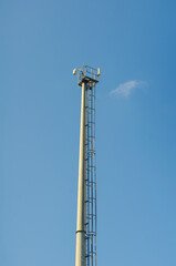 Modern communication tower rising against vibrant blue sky, perfect for telecommunications infrastructure or wireless networking communications solutions