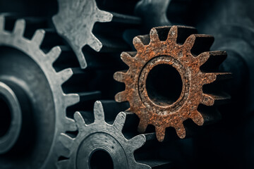Rusted Gear in the Machine. A rusty gear among new ones. Coming to a halt, teamwork or shutdown. Abstract concepts. Industrial background banner. Needing maintenance.