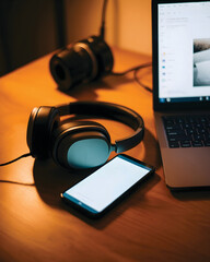 Digital Media and Remote Work: Headphones, Smartphone, and Laptop on Wooden Desk
