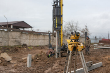 Setting up of a piling rig at the construction site. From the side, you can see concrete piles already driven into the ground. High quality photo