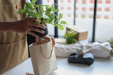 A small business, a florist or a gift shop worker preparing a customer's order.