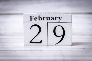 The wooden calendar displays the date February 29, symbolizing leap years. This unique date occurs every four years, highlighting special occasions and time management.