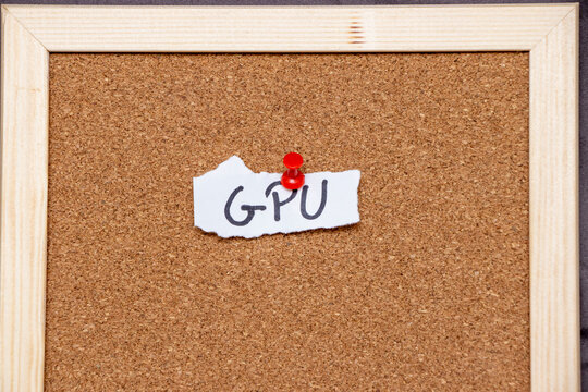 Handwritten note saying GPU pinned to corkboard with a red pushpin. Ideal for topics related to technology, computing, or graphics. Emphasizes organization and reminders.