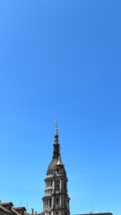 Skyward Ascent: A majestic steeple, a testament to architectural prowess, reaches towards an expansive azure sky, creating a striking contrast of height and color.