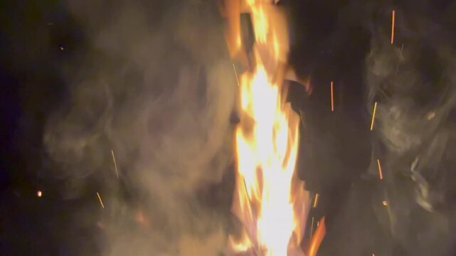 Fire flame with sparks and smoke at night. Abstract background of burning fire.