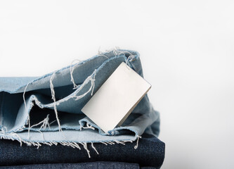 Blue denim jeans with fringe and label with space for text on a white background