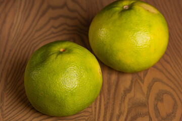 Two Green Pomelo Citrus Fruits on Wooden Table
