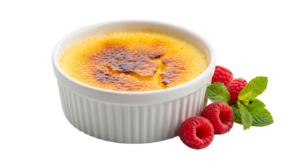 Delicious creme brulee dessert in a ramekin with fresh raspberries and mint garnish is a decadent and creamy treat.