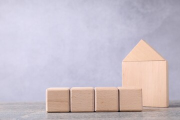 Blank cubes and house model on wooden table. Mockup for design