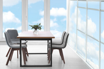 Table and chairs near windows in room. Interior design