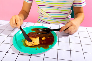 Child cutting flan dessert on vibrant plate with tools