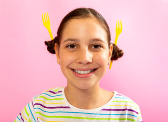 Playful girl smiling with unique yellow fork hairstyle