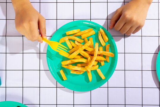 French fries served on a vibrant plate with a fork