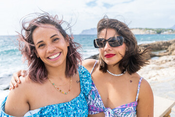 Friends enjoying a beach day with smiles and sunglasses