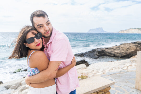 Friends embracing by the ocean for inclusive friendship