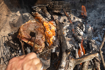 Grilled steak sizzling over open fire with smoky aroma