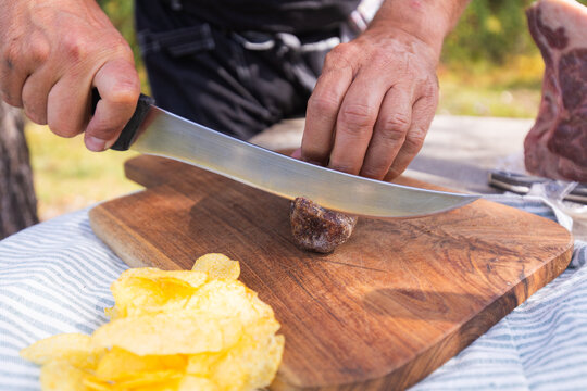 Outdoor meat preparation with sharp knife